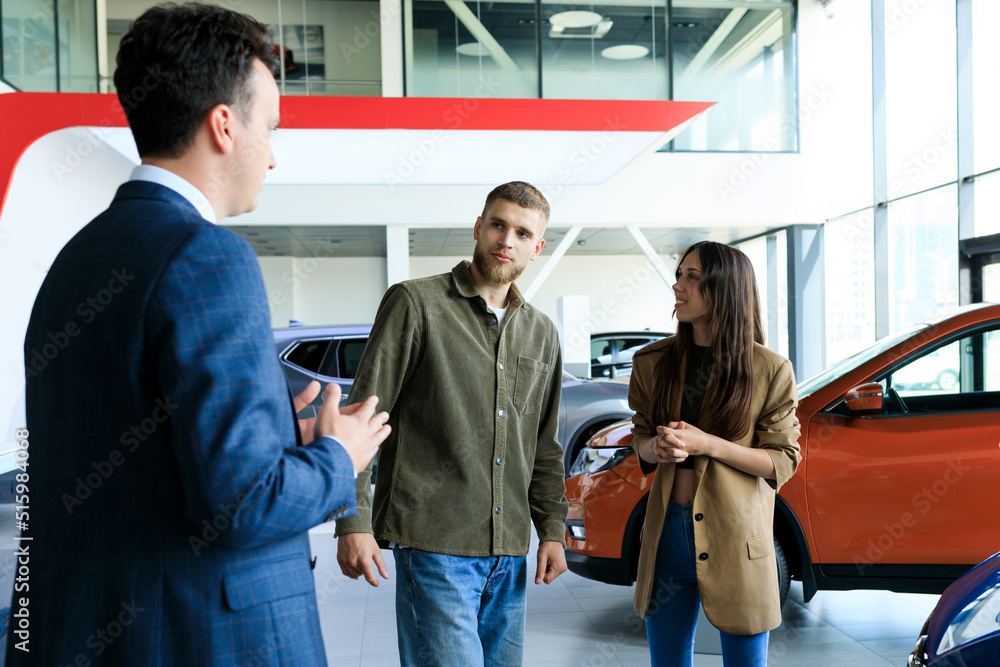 Foto de Buying a family car. A car dealership employee shows new luxury