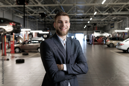 Manager for the acceptance of cars for repair. A man stands against the background of a service station © makedonski2015