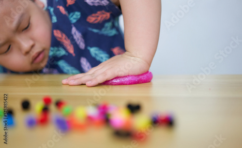 kid play slime on table by press