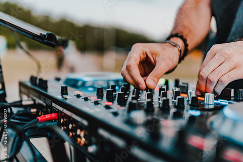 Fotografia DJ Hands creating and regulating music on dj console mixer in concert outdoor