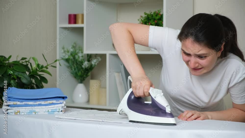 A female housewife barely strokes a baby diaper. Bad iron and difficult ironing. A female housewife barely strokes a baby diaper. Bad iron and difficult ironing.