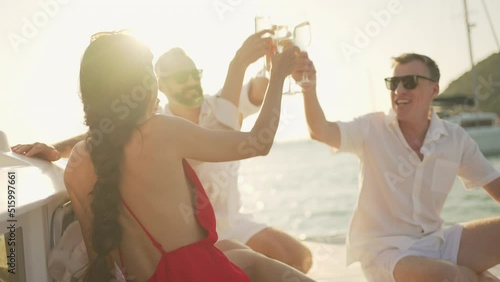 Caucasian man and woman enjoy luxury outdoor lifestyle celebrating holiday party and toasting champagne glass together while catamaran yacht boat sailing in the sea at summer sunset on travel vacation