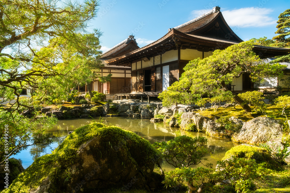 Beautiful traditional Japanese architecture in the golden light with reflections in the pond at the Silver Pavillion or Ginkaku-Ji Zen Temple and gardens, a 'must-see' destination in Kyoto, Japan.