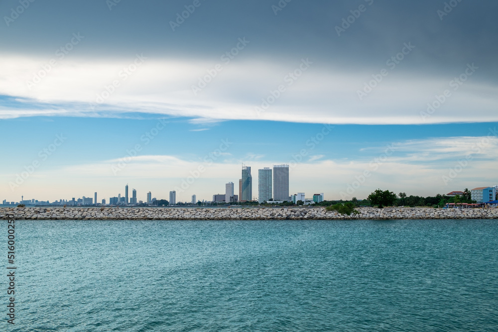 Seascape with the city on a horizon against the blue sky.