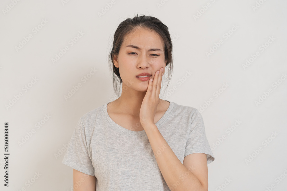 Closing eyes asian young woman touching cheek, face expression from toothache, tooth decay or sensitivity, Having tooth or teeth problem or inflammation, suffering from health. Sensitive teeth people Closing eyes asian young woman touching cheek, face expression from toothache, tooth decay or sensitivity, Having tooth or teeth problem or inflammation, suffering from health. Sensitive teeth people