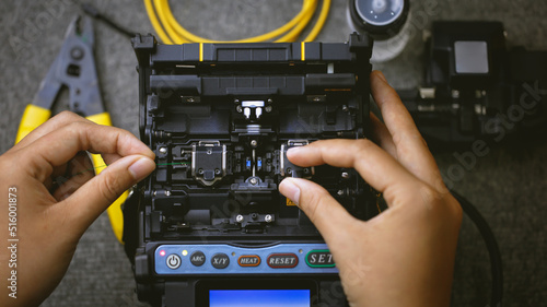 Fiberoptic Fusion Splicing Technician , Internet cable connection, fiber optic fusion splicing machine. Concept of fiber optic connection by skilled technicians.