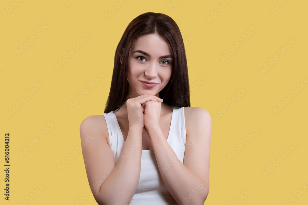 Portrait of attractive coquettish cute funny cheerful girl in white top isolated on yellow background Portrait of attractive coquettish cute funny cheerful girl in white top isolated on yellow background