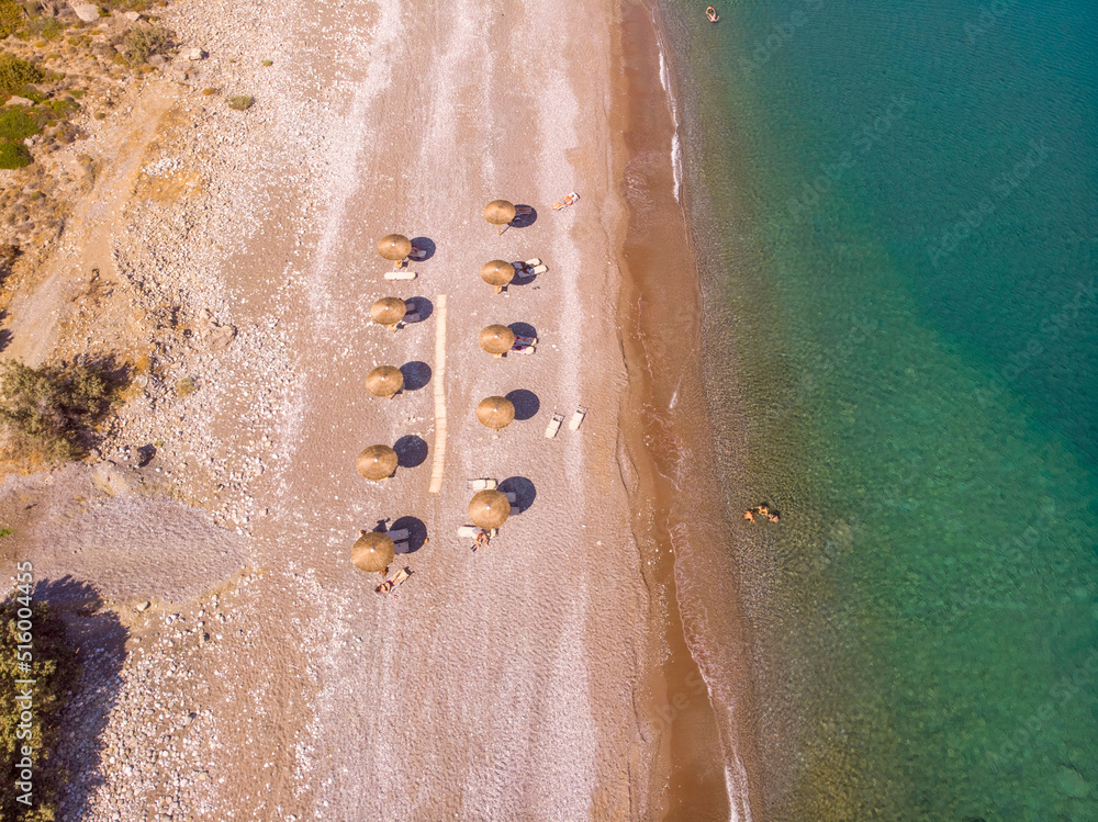 Aerial view of a beach in Greece with ten sunchairs and parasols