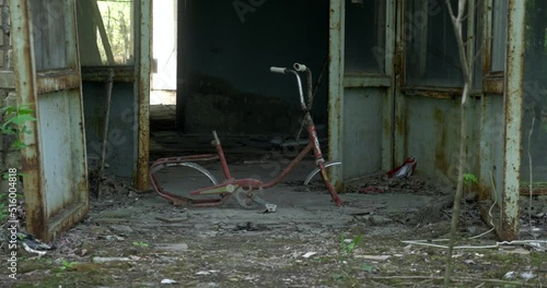 Old broken bicycle in front of ruined building