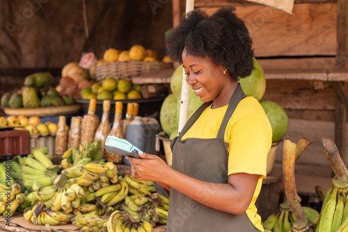 Canvas Print african market woman using a pos device and a credit card