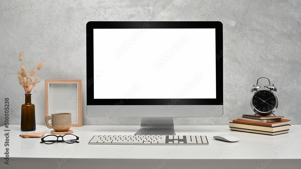 Fototapeta premium Front view computer with empty display, picture frame, books and alarm clock on white table