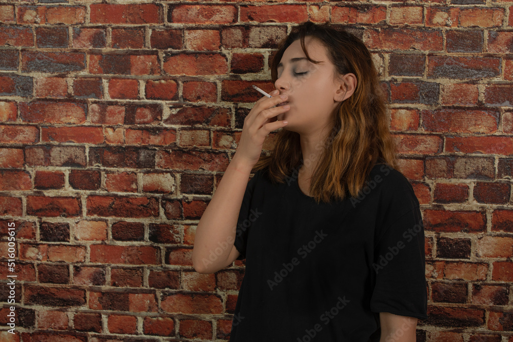 Young depressed girl smoking cigarette.