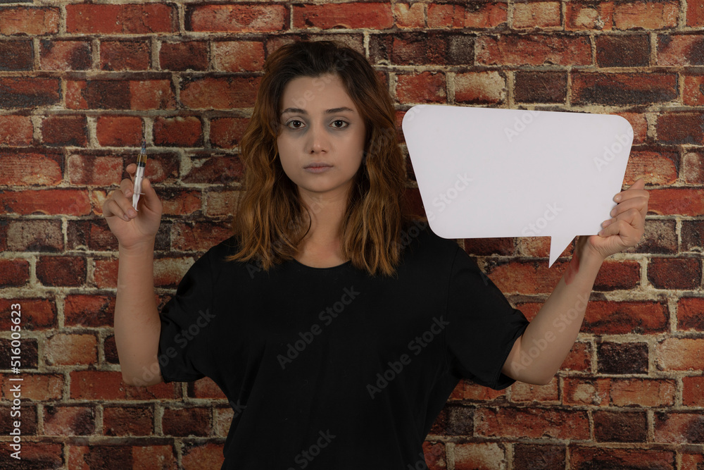 Young addicted girl holding injection and white idea board Young addicted girl holding injection and white idea board