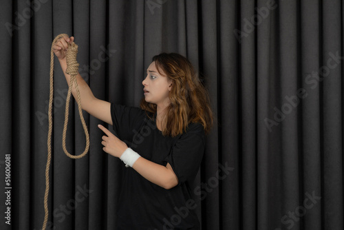 Young girl holding suicide rope and saying no to it.