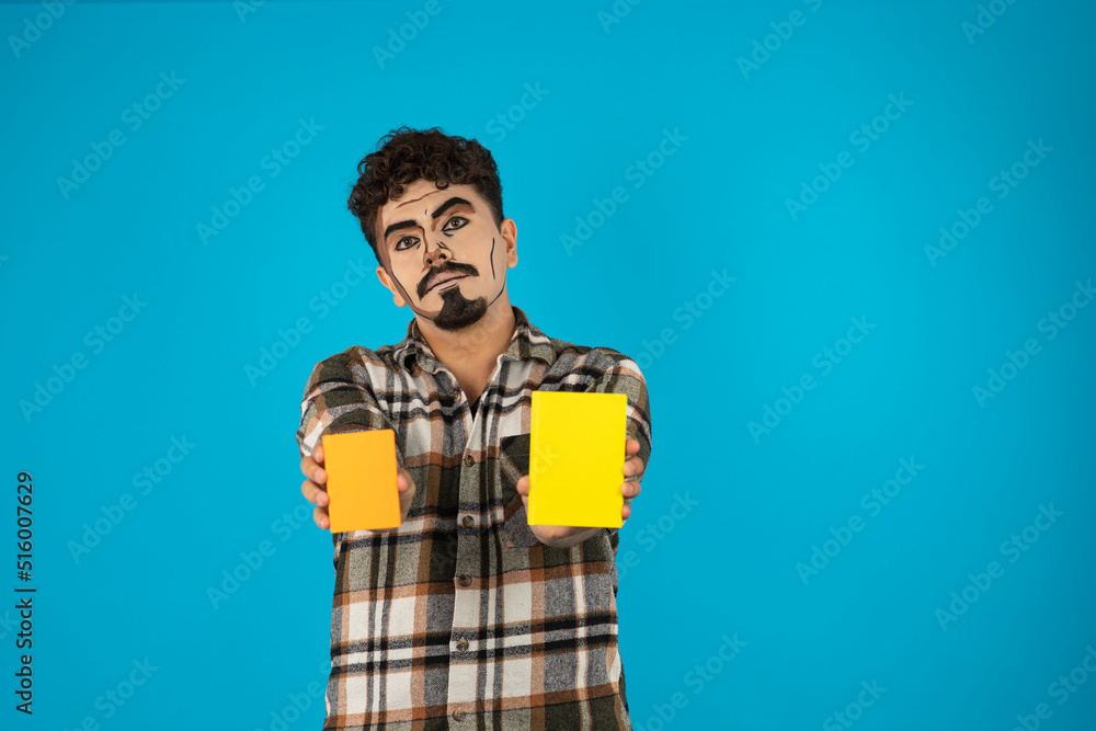 Young guy holding two yellow idea board and showing them to the camera Young guy holding two yellow idea board and showing them to the camera