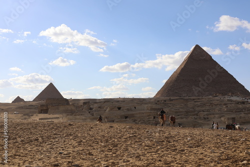 Pyramids of Giza. Scene with tourists near pyramid in Egyptian desert. Travel to the African continent for look of a UNESCO World Heritage Site. 