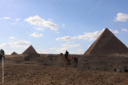 Pyramids of Giza. Scene with tourists near pyramid in Egyptian desert. Travel to the African continent for look of a UNESCO World Heritage Site. 