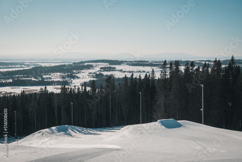 Alpine skiing slope (Ladängen, Frösön, Östersund) with a mountain view towards Storsjöbygden and Oviksfjällen at the border between swedish winter and spring.