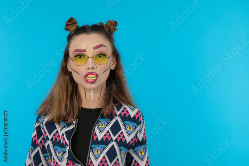 Attractive beautiful girl wearing fantasy makeup and stand blue background