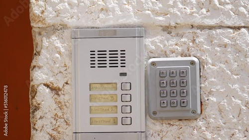 Antique iron mailbox next to the modern front door. Intercom and intercom. Keyboard with numbers to call subscribers. Call buttons for residents of the house. Croatia, Istria, Rovinj - July 7, 2022