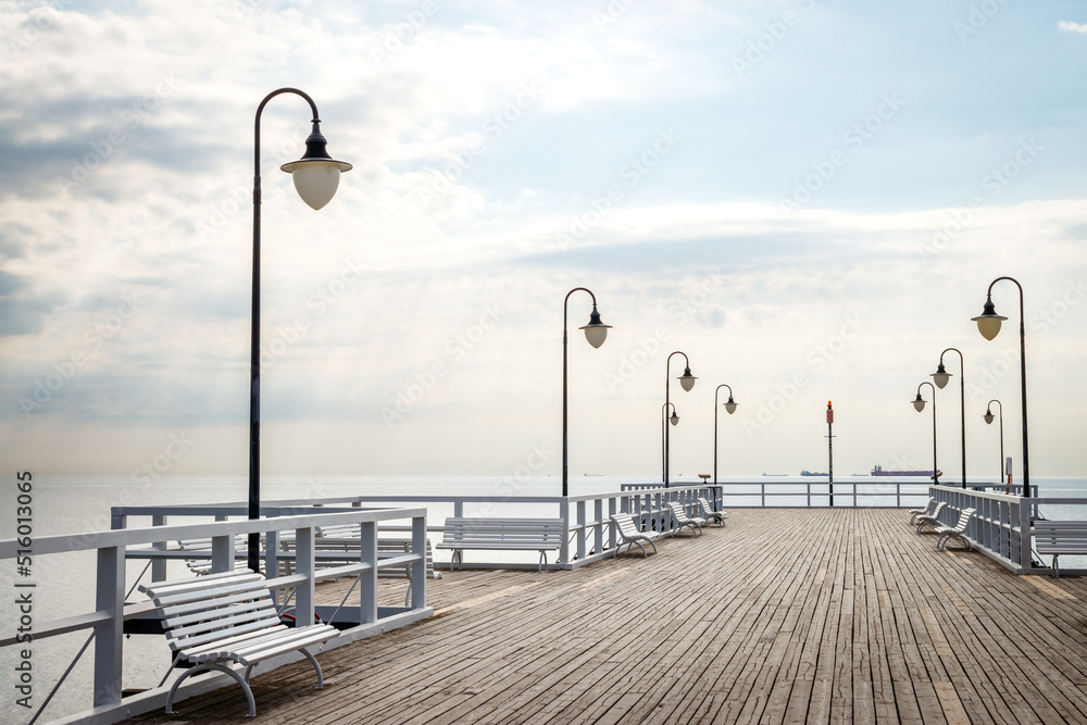 Pier with empty benches in Gdynia Orlowo, Poland. Travel destination at coastline of Baltic sea