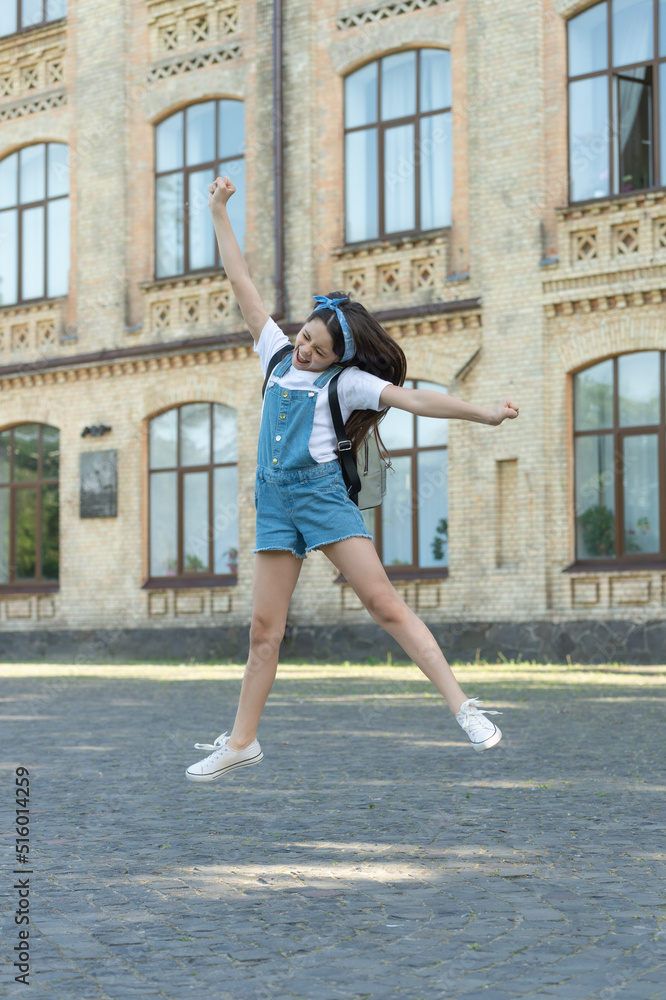 happy and glad girl with backpack jumping outdoor