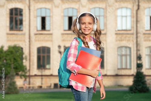 Happy teen girl back to school outdoors, music