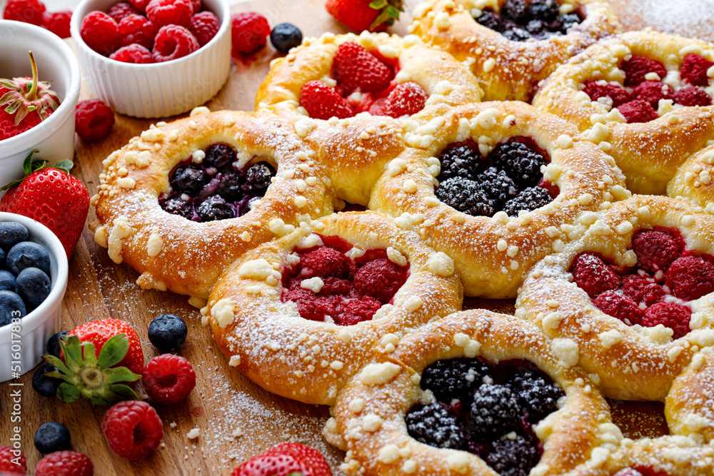Homemade sweet yeast buns with the addition of berry fruit and butter crumble, sprinkled with powder sugar, close up view Homemade sweet yeast buns with the addition of berry fruit and butter crumble, sprinkled with powder sugar, close up view