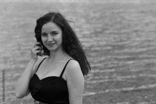 Outdoors portrait of young curly woman in black and white