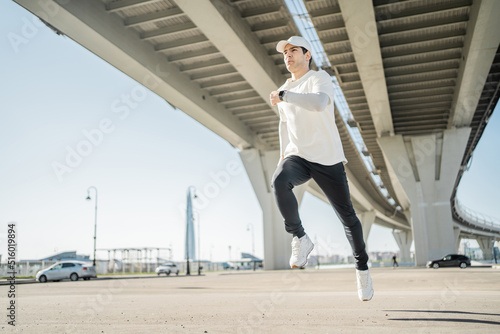 A runner is running a sporty confident man training fitness on the street in comfortable sports clothes