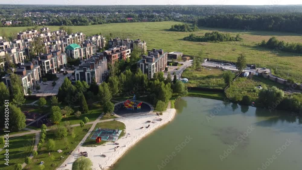Aerial view of green lake with beach, landscape park, residential houses, neighborhood, suburb. Real estate, drone shots from above Aerial view of green lake with beach, landscape park, residential houses, neighborhood, suburb. Real estate, drone shots from above