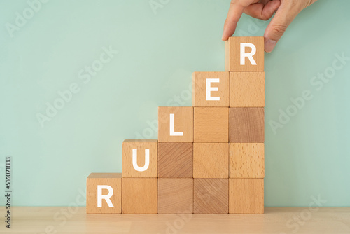 支配者、定規のイメージ｜「RULER」と書かれたブロックと手 