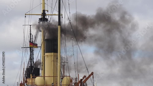 Yellow chimney of a coal steamer steams black smoke