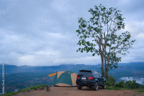 Camping with a Toyota Fortuner 4x4 and tent in a beautiful morning with fog on the mountains at Doi Mon Mak Campground is a campsite in Mae Chaem, Chiang Mai, Thailand. photo