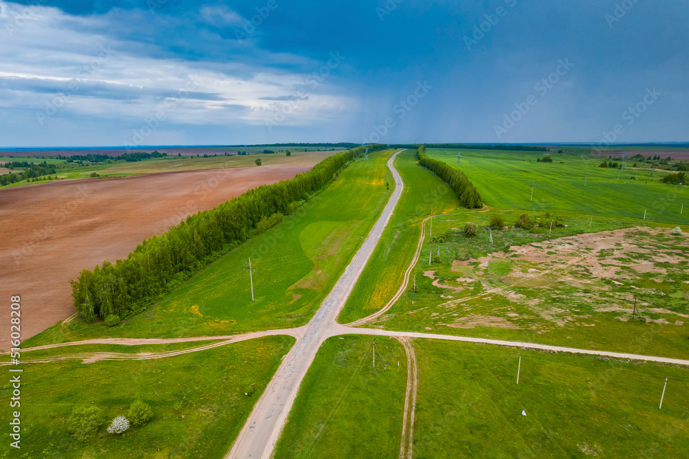 The road through the fields. View from a height. Agricultural fields. Summer landscape. 