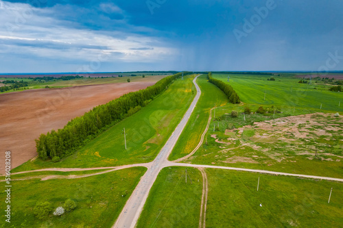 The road through the fields. View from a height. Agricultural fields. Summer landscape. 
