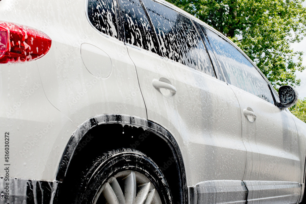 Washing mirrors in a white car with active foam. Car wash Stock Photo Adobe Stock