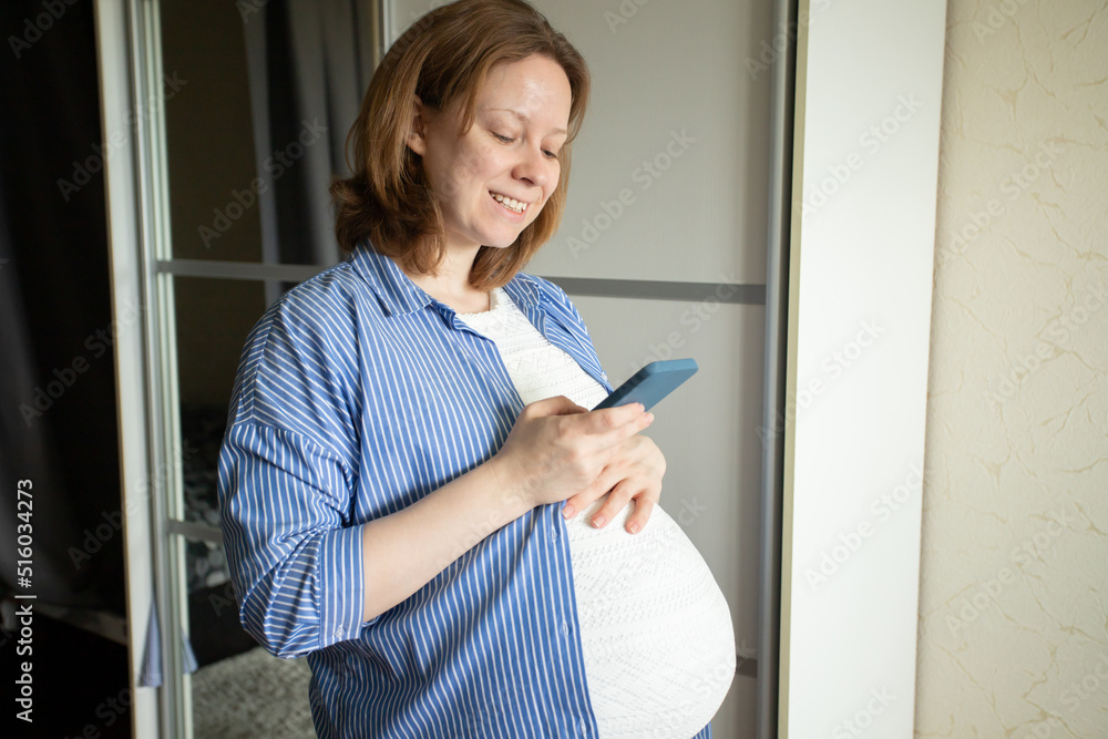 pregnant woman with a phone at home, online pregnancy management, smartphone help, doctor's consultations, preparation for childbirth pregnant woman with a phone at home, online pregnancy management, smartphone help, doctor's consultations, preparation for childbirth