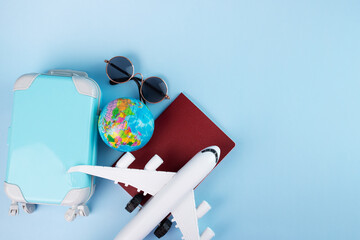 international insurance, travel and tourism, trips and tours, summer holidays and vacations, passport, plane and luggage on a blue background with copy space