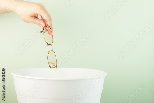 good vision concept, eye surgery, contact lenses, correction, hand throws glasses in the trash
