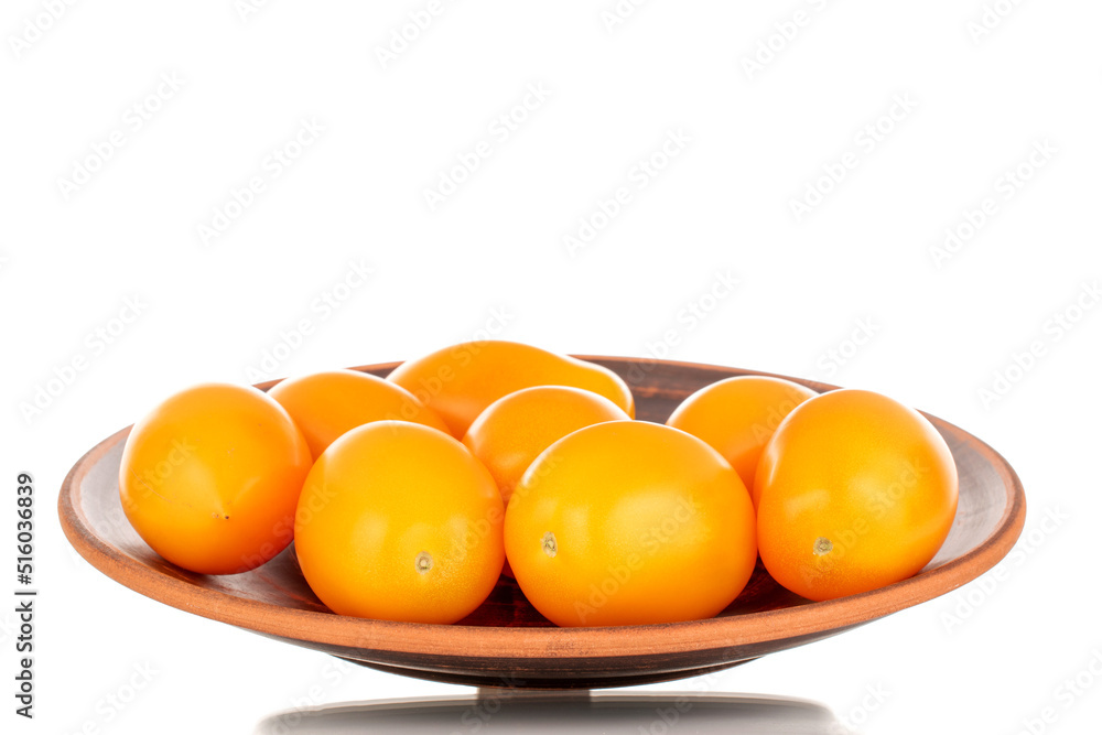 Several ripe yellow tomatoes on a ceramic plate, close-up, isolated on a white background. Several ripe yellow tomatoes on a ceramic plate, close-up, isolated on a white background.
