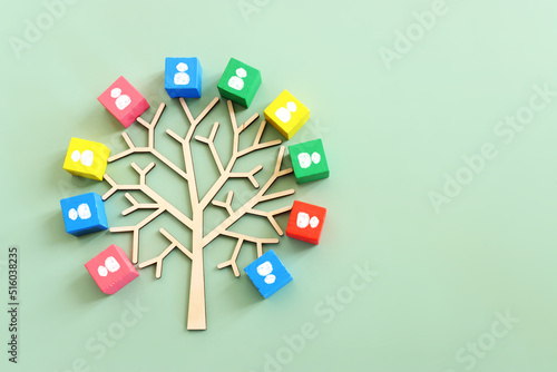 Business image of wooden tree with people icons over green background, human resources and management concept © tomertu