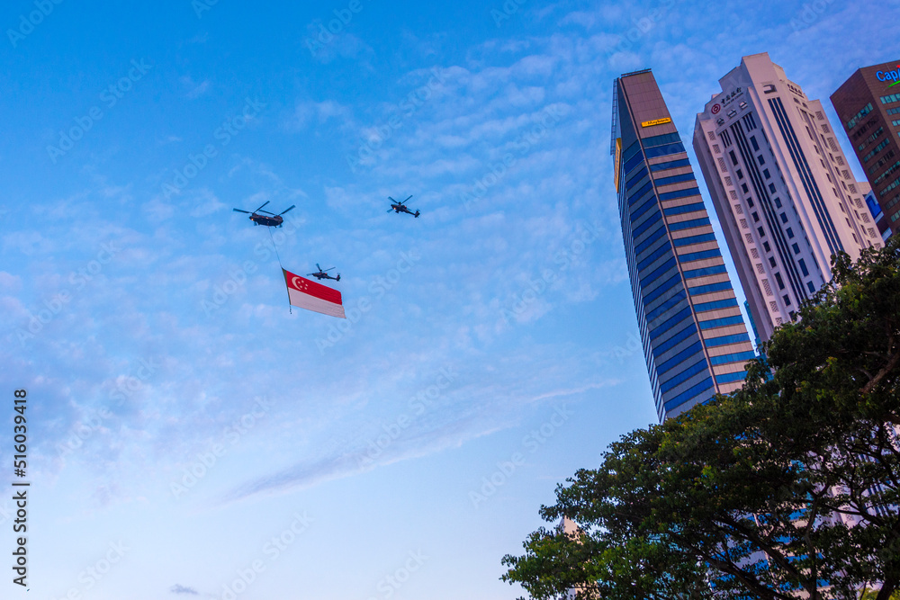 The helicopter carries the flag of Singapore on the National Day Parade ...