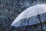 Transparent umbrella under heavy rain against water drops splash background. Rainy weather concept.