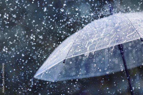 Fototapeta Transparent umbrella under heavy rain against water drops splash background