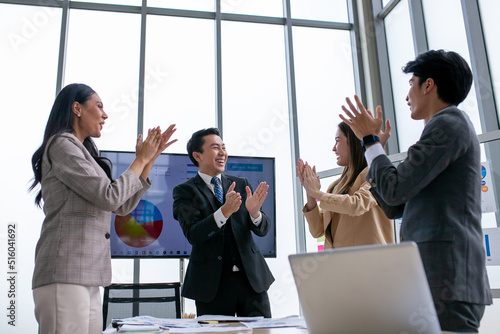 Asian business team celebrate corporate victory together in office, laughing and rejoicing, smiling excited employees colleagues screaming with joy in office. © todja