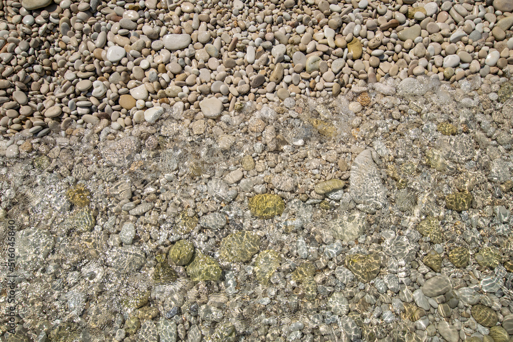 Pebbles washed by wave at Paxos island during summer Pebbles washed by wave at Paxos island during summer