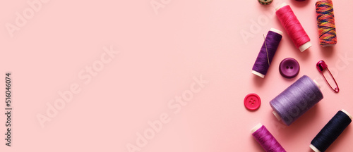 Fotografia, Obraz Colorful sewing threads and buttons on pink background with space for text