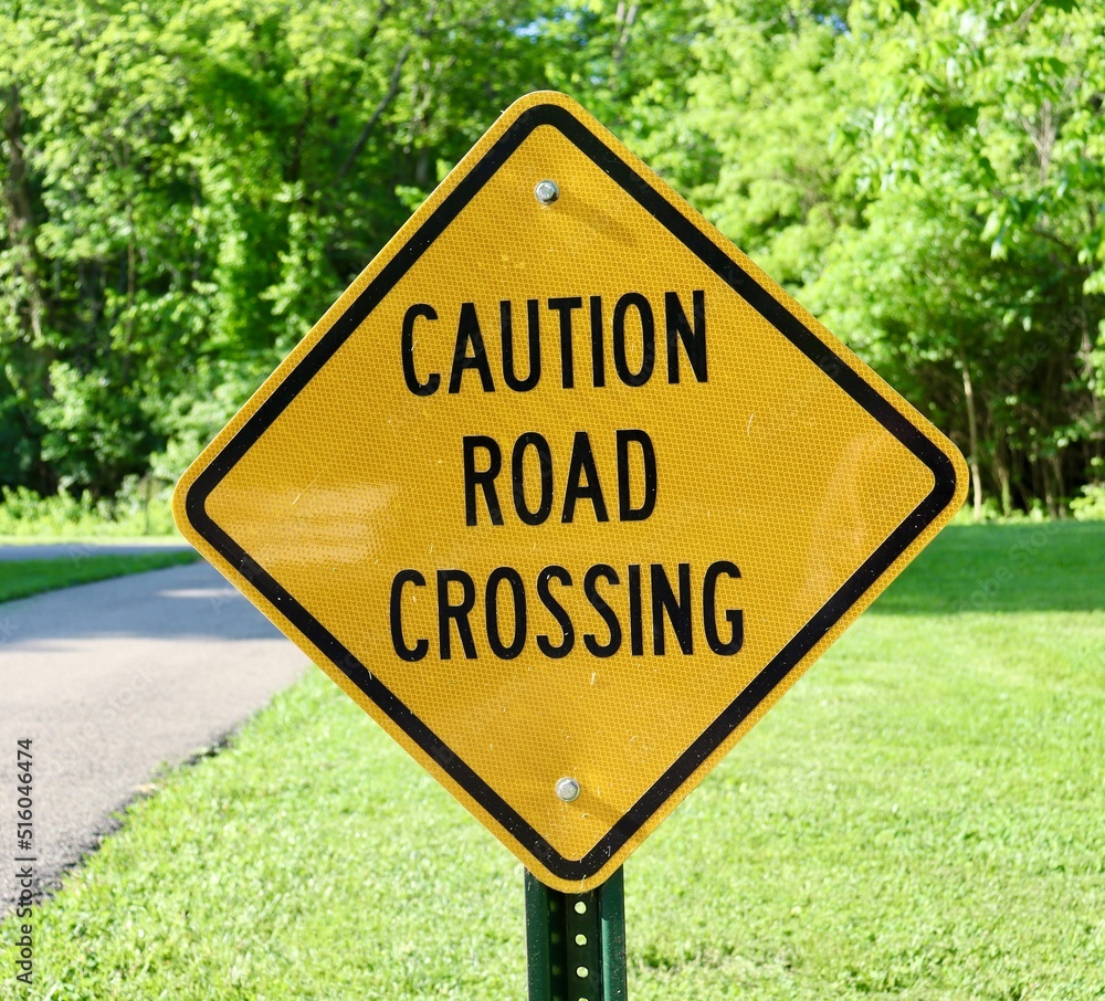 A close view of the caution road crossing sign.