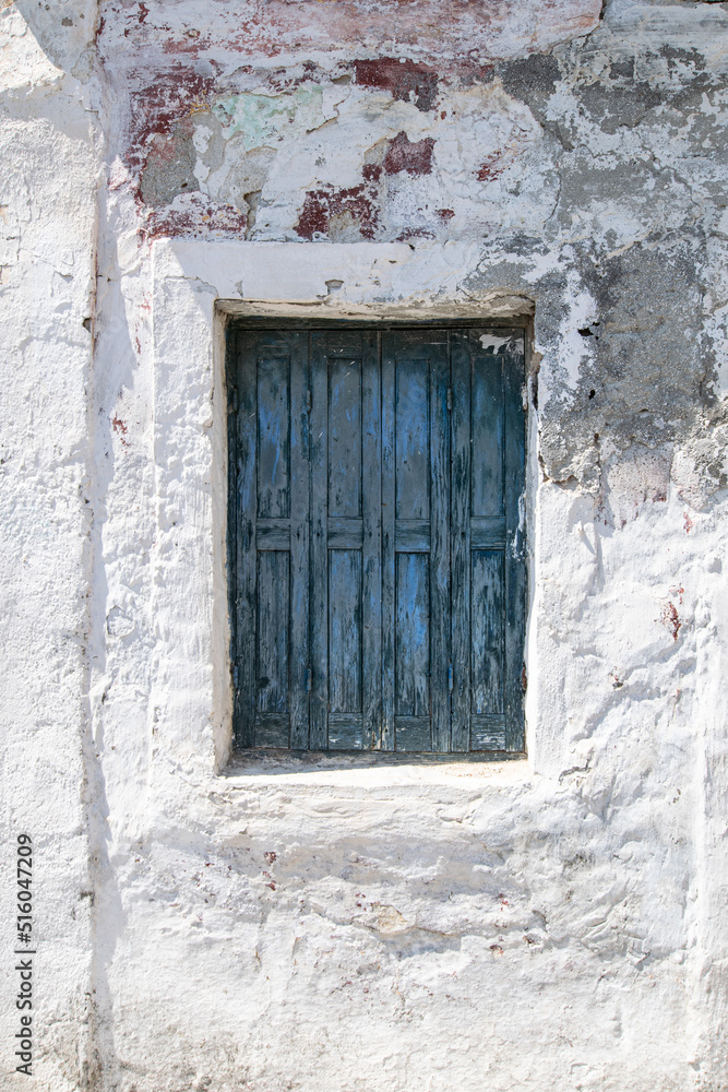 Blue rotten wooden window at old abandoned traditional house at Corfu Greece
